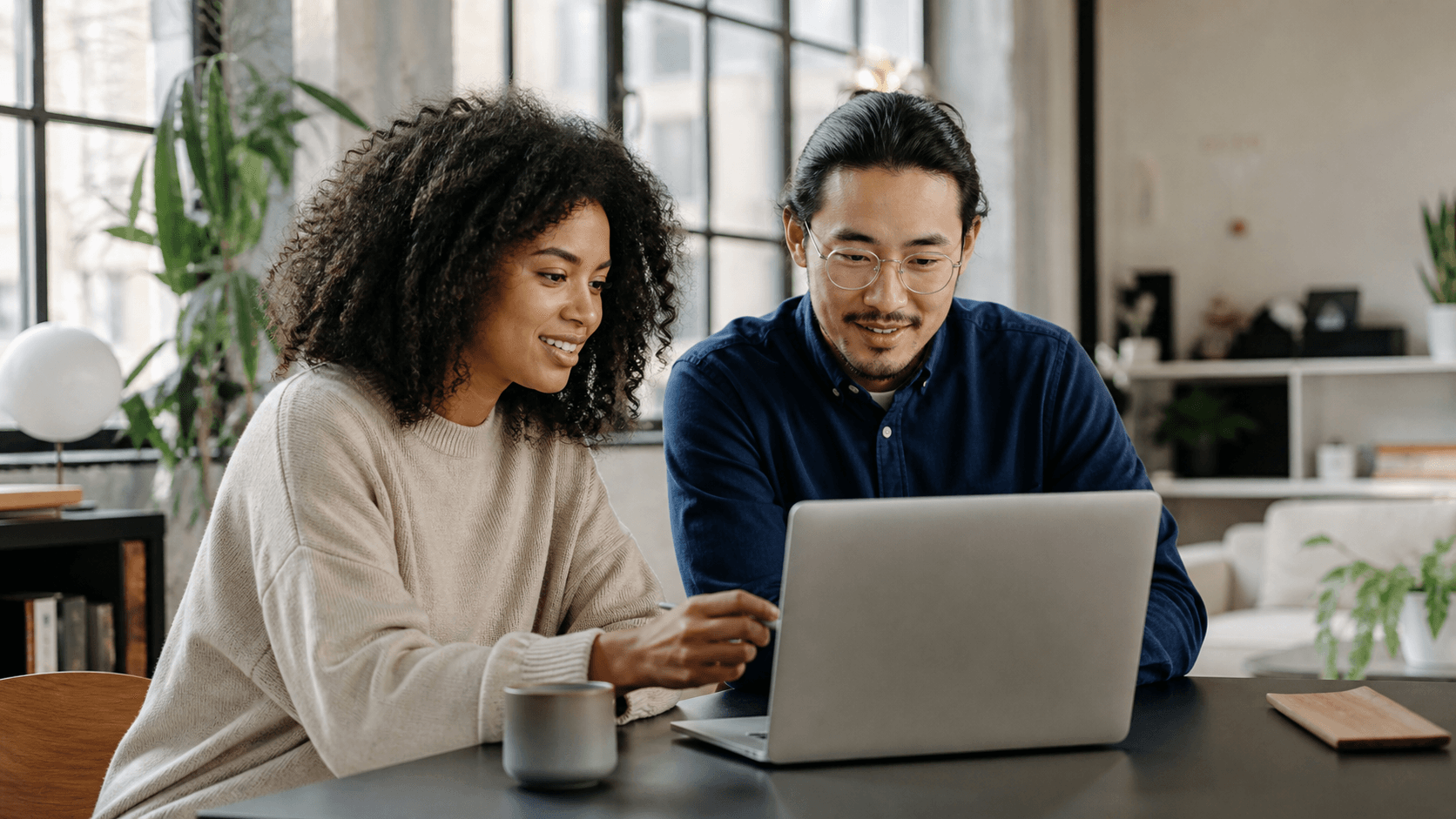 Two colleagues collaborating at a laptop during onboarding